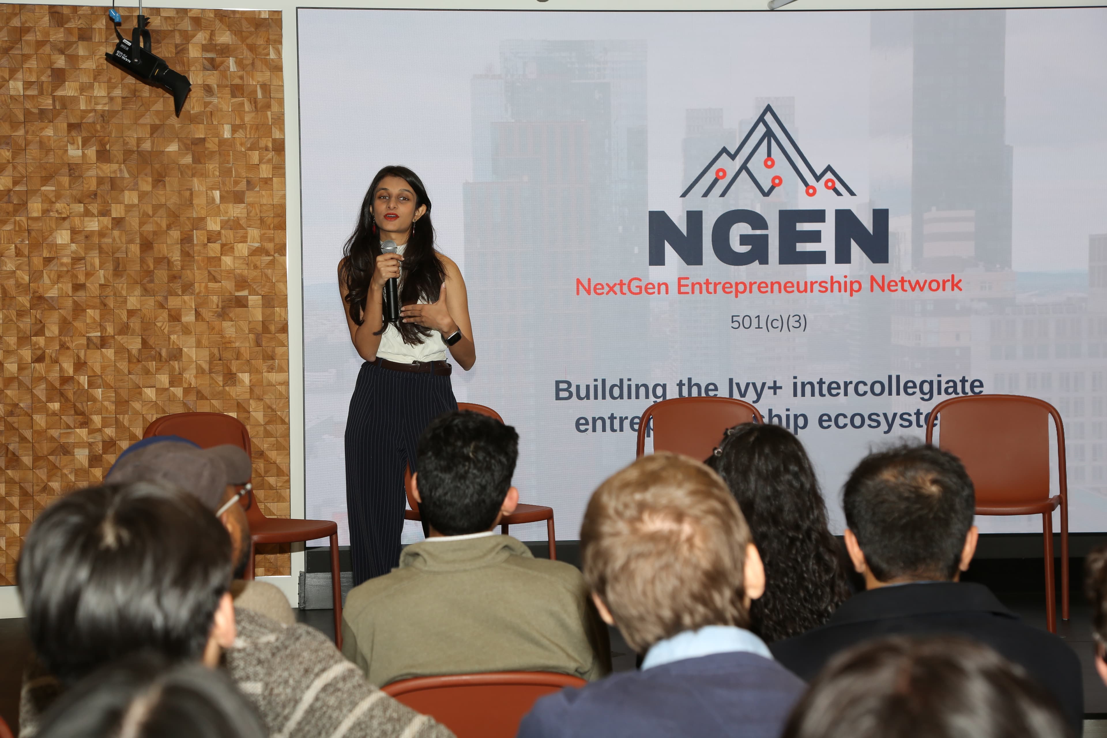 A speaker on stage in front of NGEN’s slide: building the Ivy+ intercollegiate entrepreneurship ecosystem